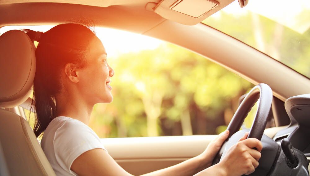 A woman is driving a car in the evening