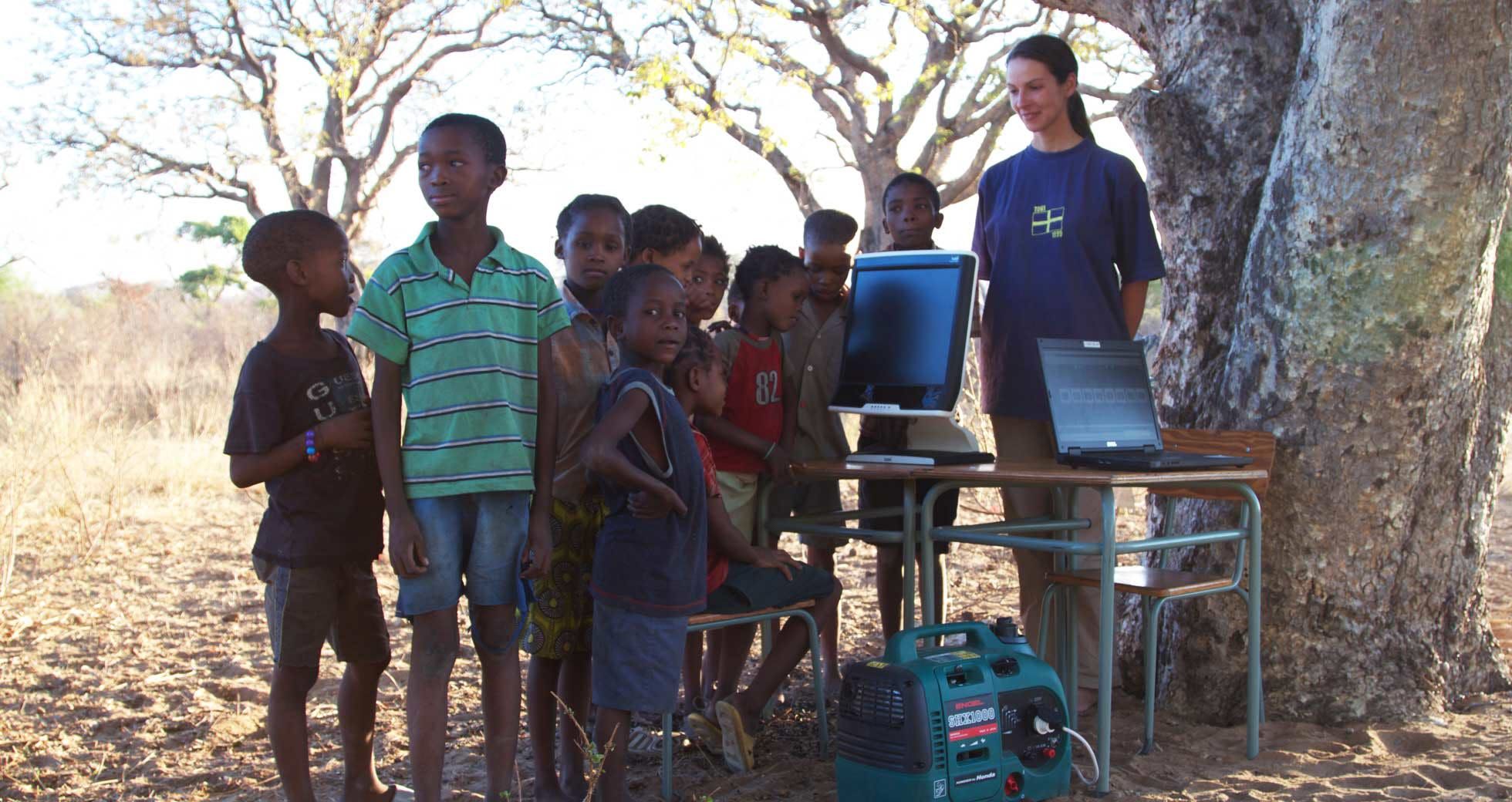 A group of school children next to a Tobii Pro T60 set up.