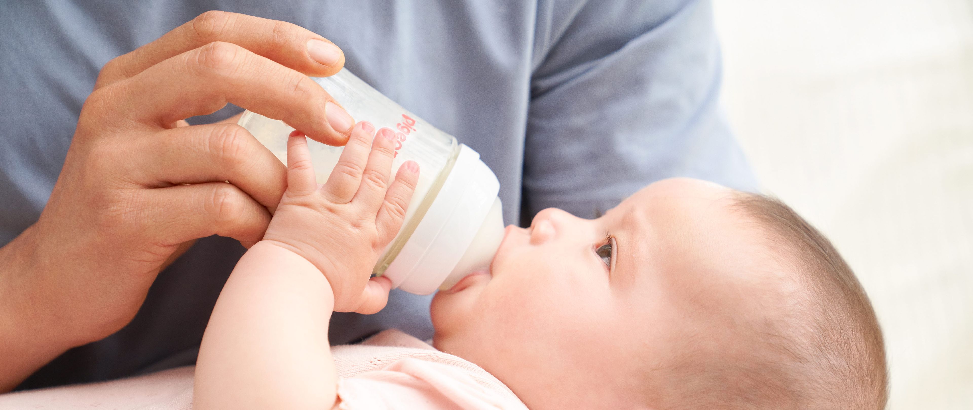 Baby drinking out of a Pigeon baby bottle