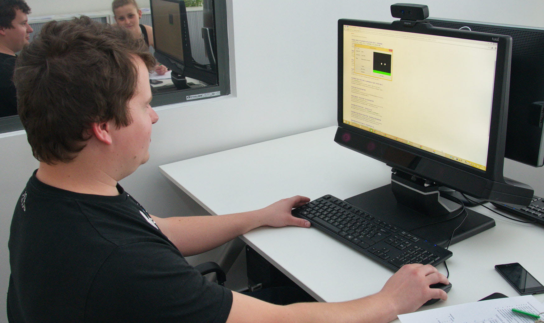A person sitting in front of the Tobii Pro TX300 eye tracker in the UX lab.