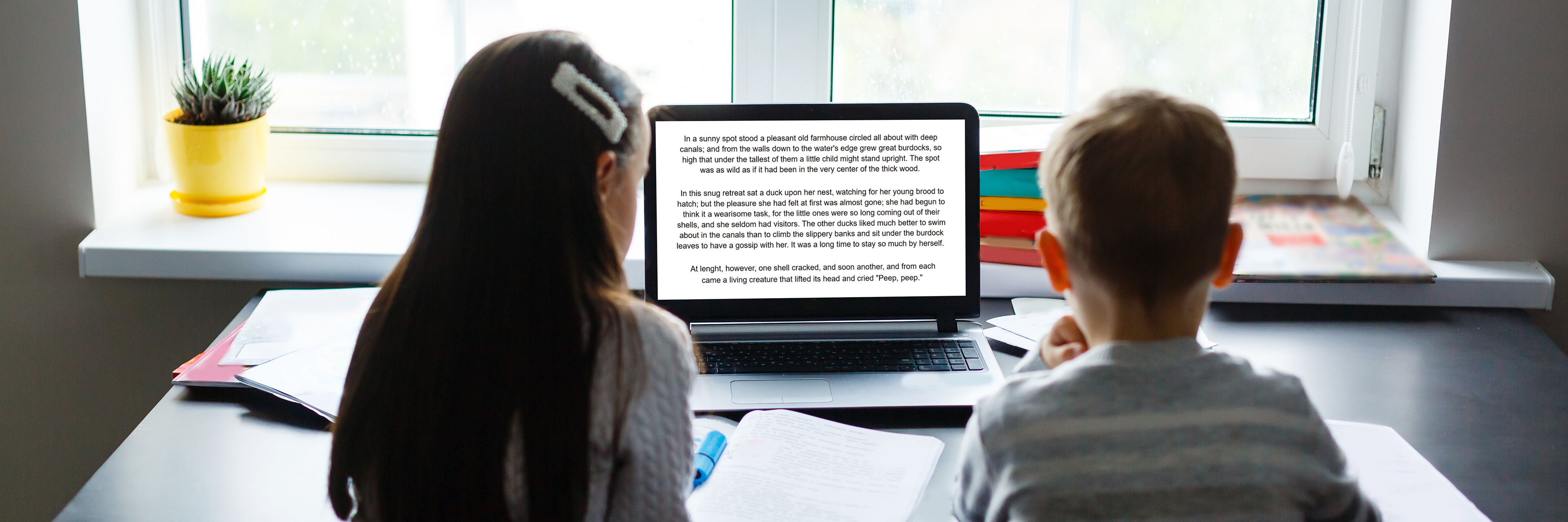 2 children reading on a laptop
