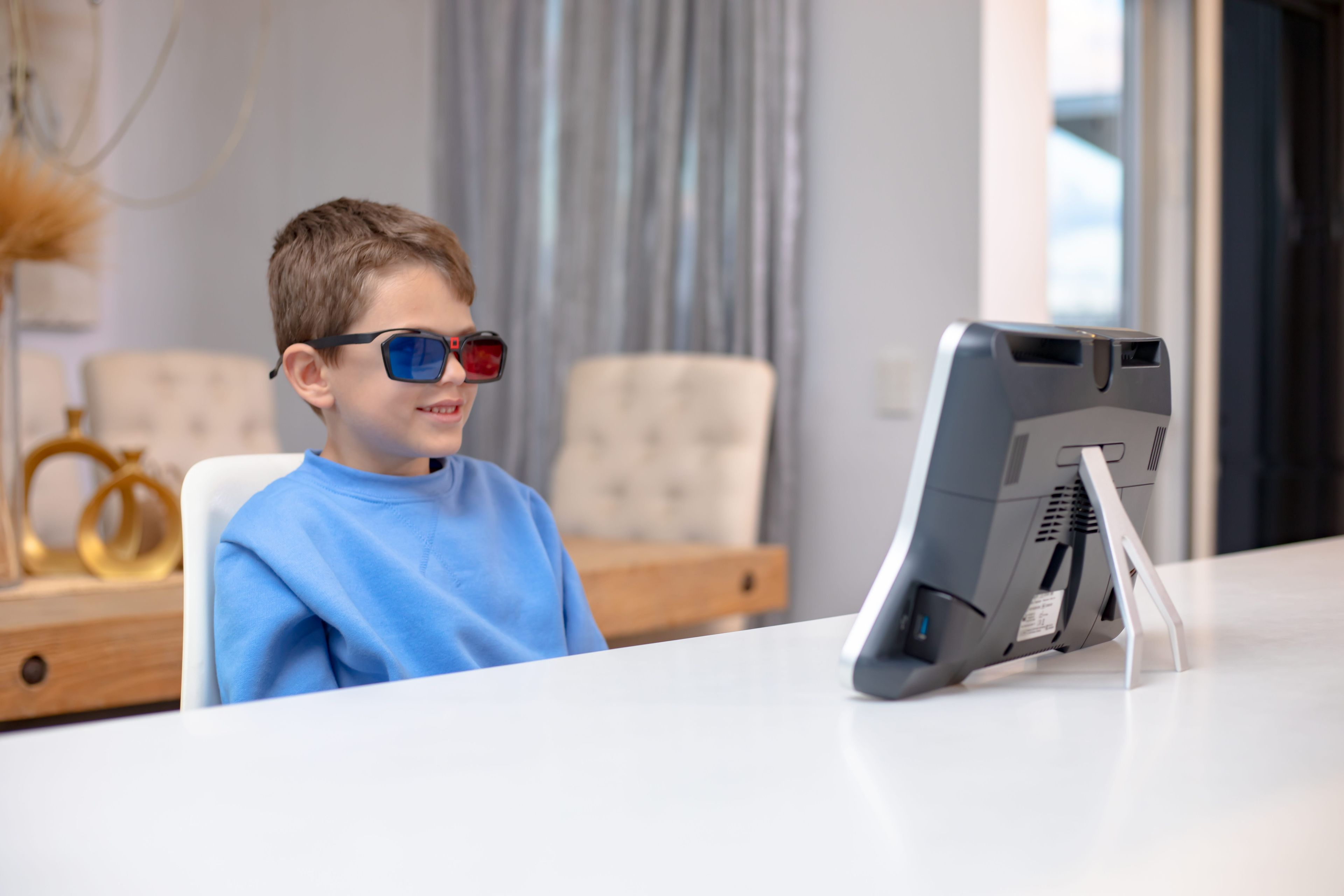 Child watching movies on a NovaSight device wearing special glasses