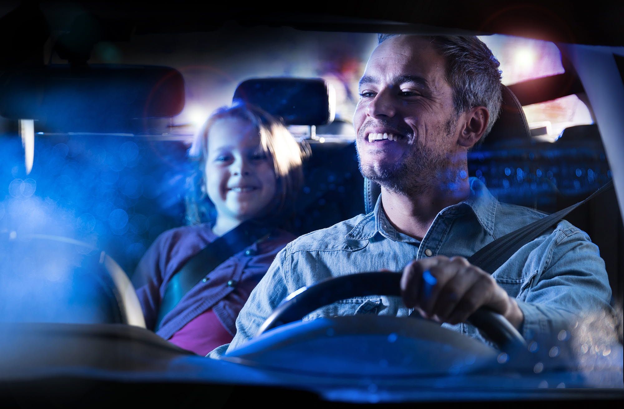 Man driving a car checking on children in the backseat