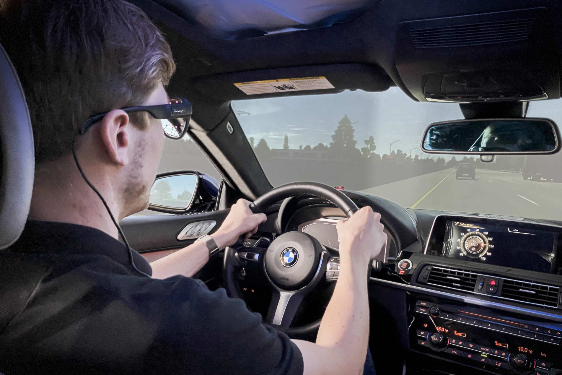 Person using Tobii Pro Glasses 3 in a driving simulator