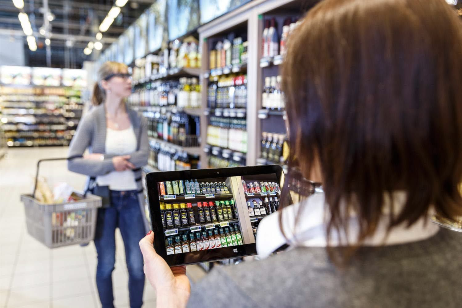 A woman wearing Tobii Pro Glasses 2 navigates in the shop while a test leader observes it through a Live View function in the Tobii Pro Analyzer software.