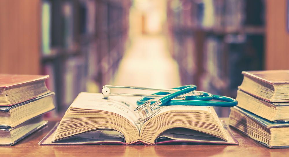 The stethoscope is placed on top of the book.