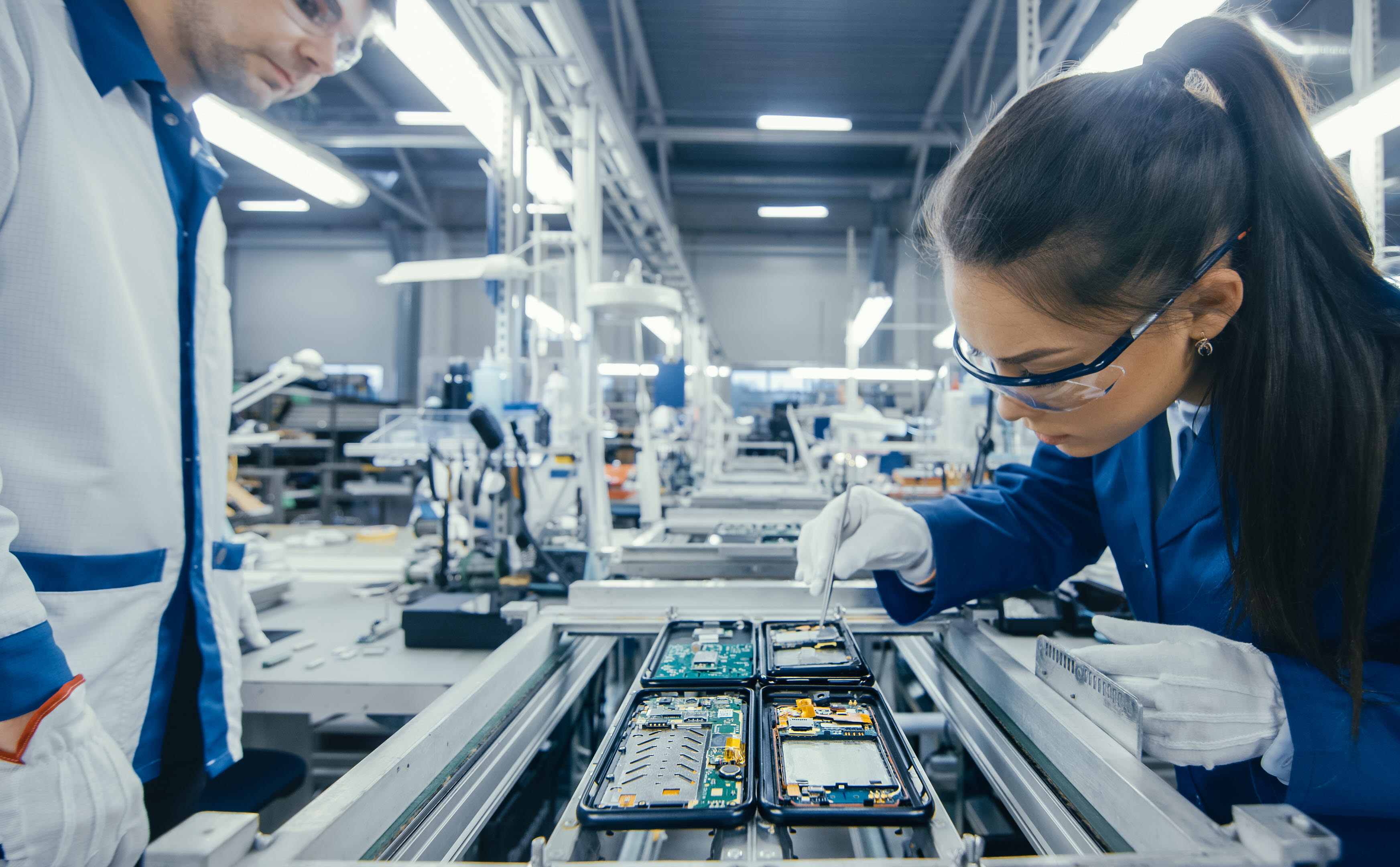 Woman working on mobile phones assembly line