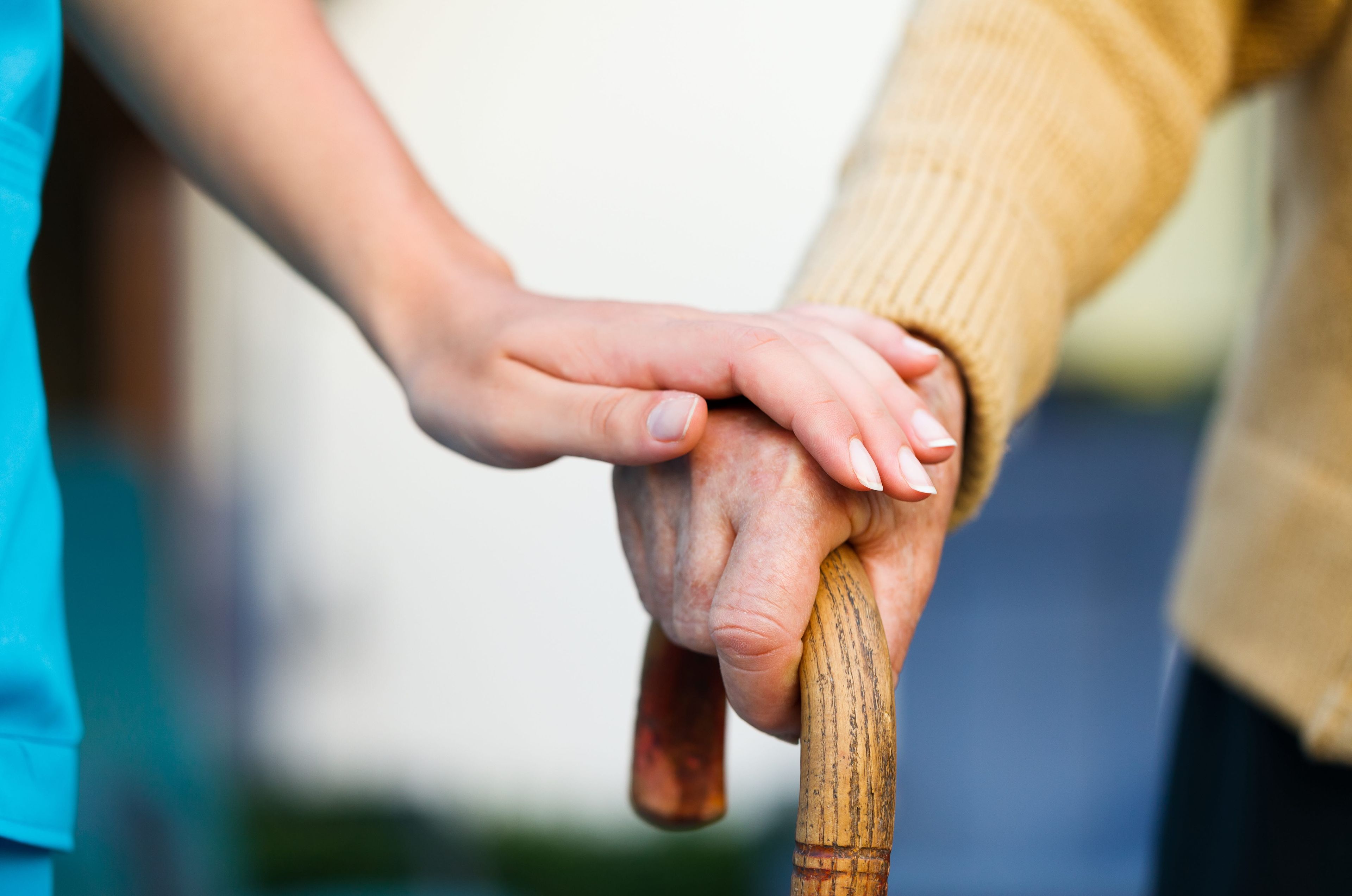 Women holding an older person's hand