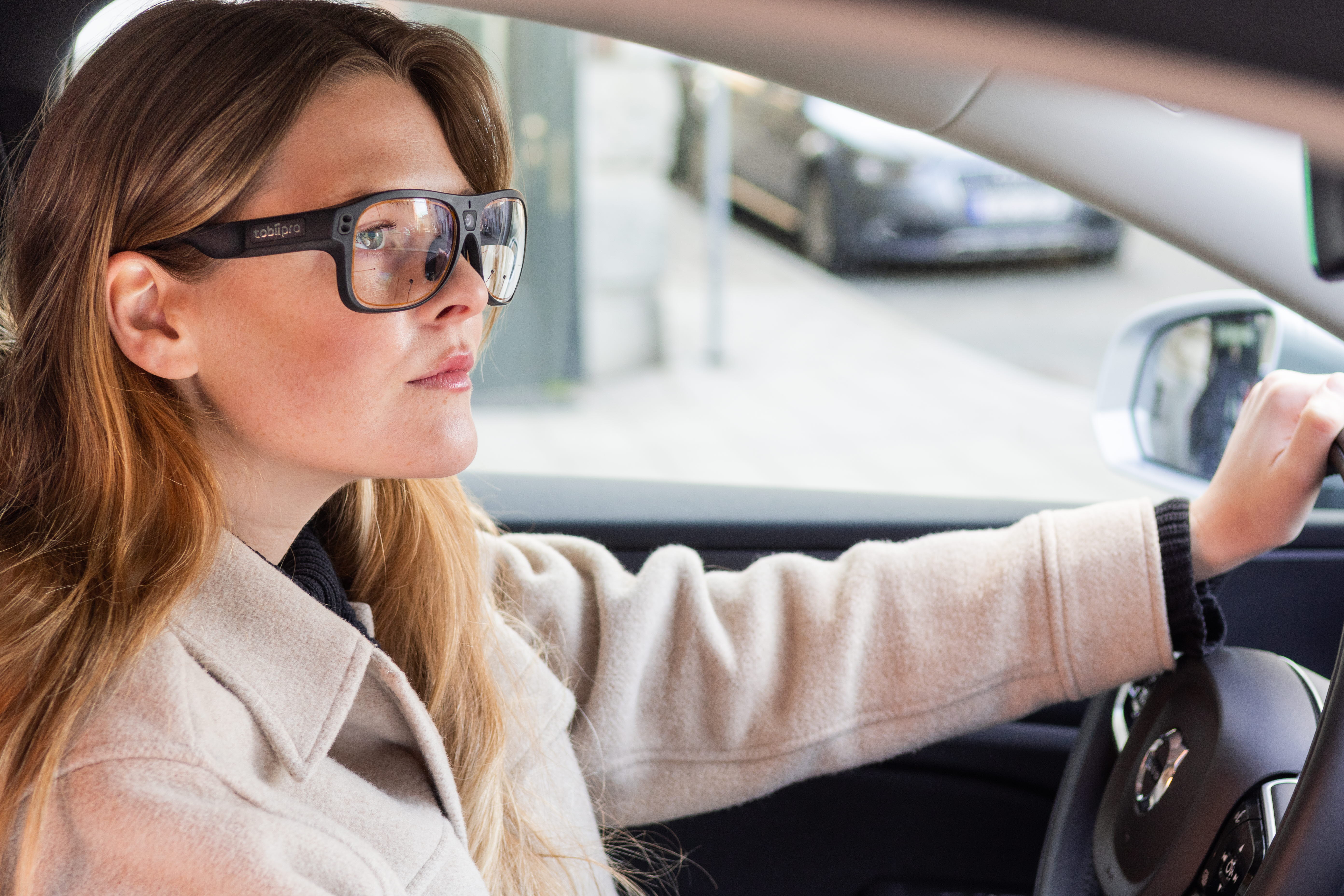 Woman using Tobii Pro Glasses 3 wearable eye trackers while driving