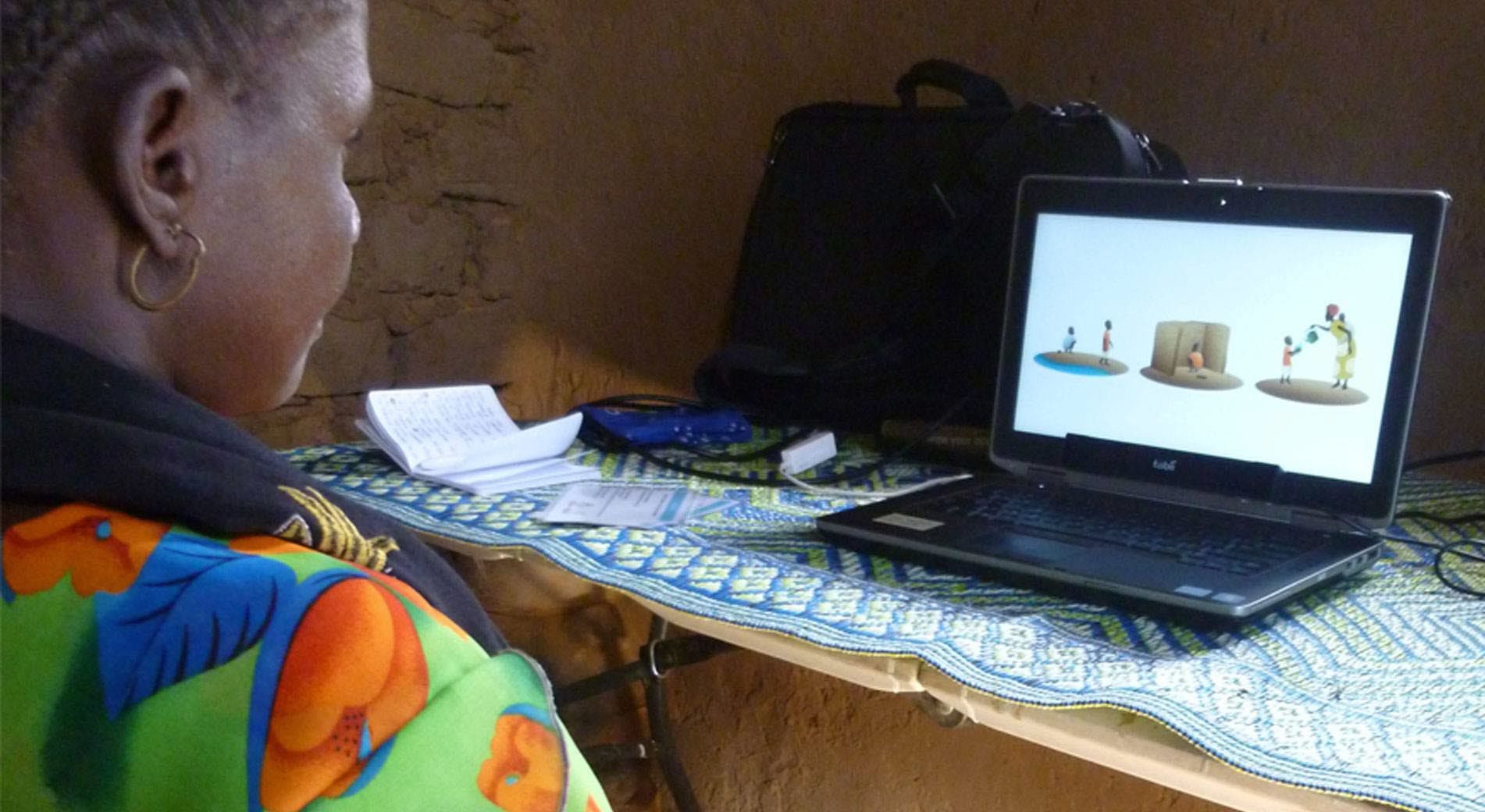 A woman performs an eye tracking test with Tobii Pro X2-60 in a traditional mud brick home.